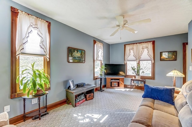 living room with baseboards, carpet floors, and ceiling fan