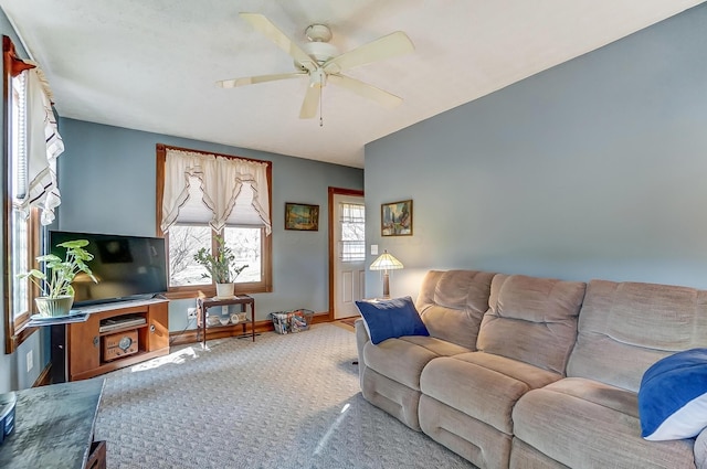 living room featuring baseboards, ceiling fan, and carpet flooring