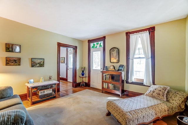 living area featuring a wealth of natural light, baseboards, and wood finished floors