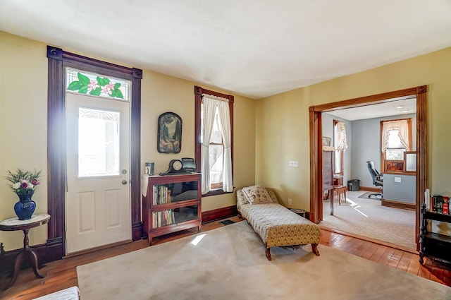 living area with hardwood / wood-style flooring, a healthy amount of sunlight, and baseboards