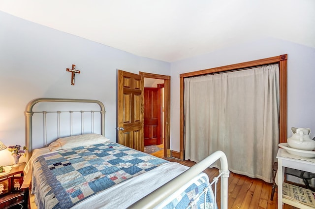 bedroom with wood finished floors and a closet