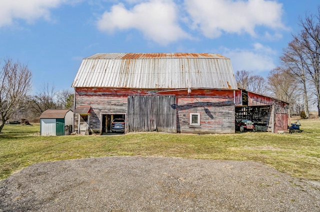 view of barn featuring a lawn and driveway