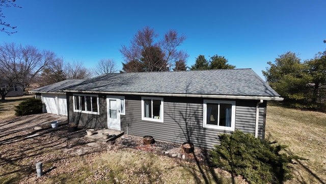 single story home featuring a shingled roof and a garage