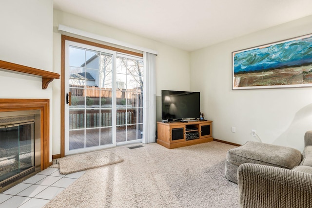 carpeted living room with a fireplace with flush hearth, baseboards, and visible vents