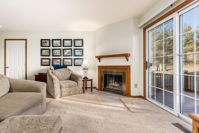 carpeted living room with a fireplace with flush hearth, baseboards, and visible vents