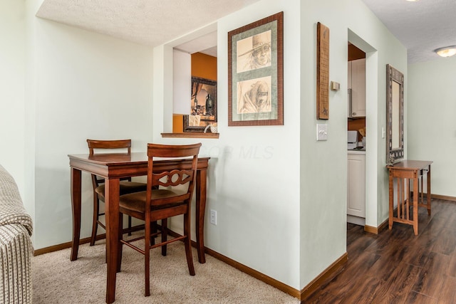 dining room with baseboards, a textured ceiling, and wood finished floors