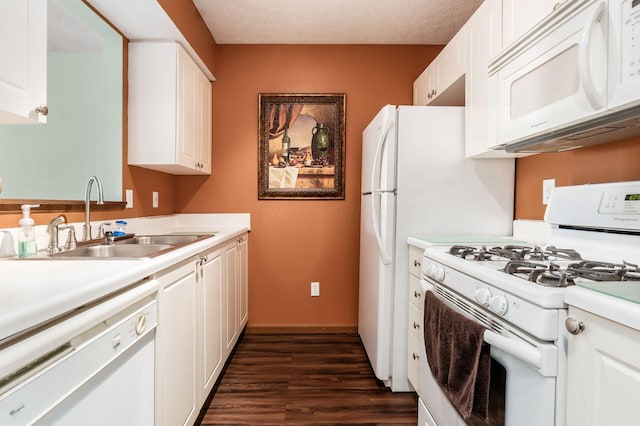 kitchen featuring white appliances, white cabinetry, and a sink