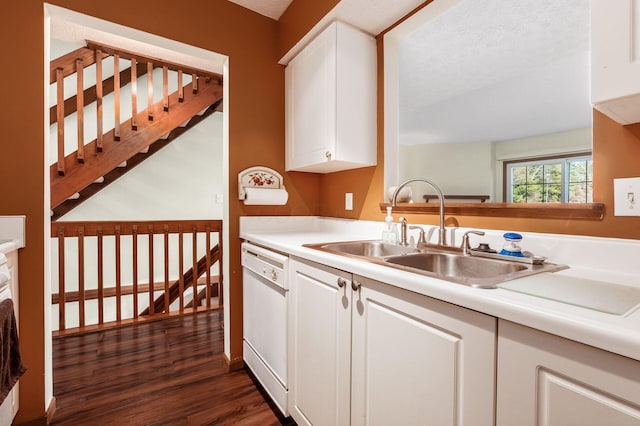 kitchen with white dishwasher, a sink, dark wood-type flooring, white cabinets, and light countertops