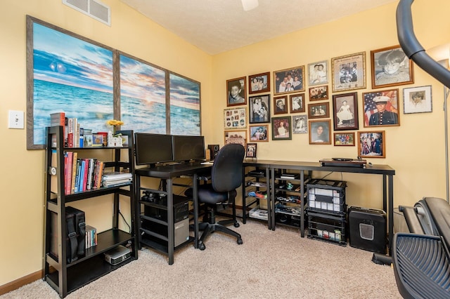 office area with visible vents, carpet flooring, a textured ceiling, and baseboards