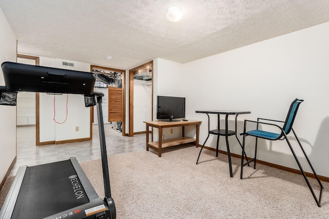 workout room featuring visible vents, baseboards, and a textured ceiling