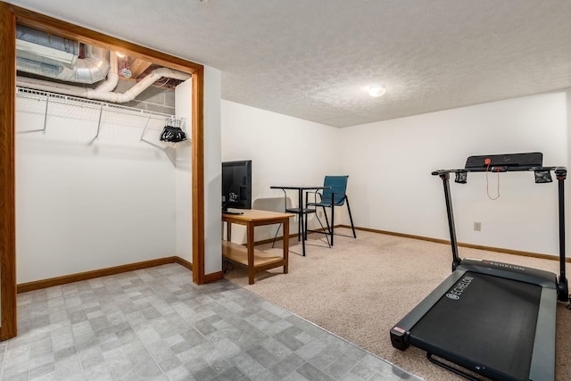 workout area with baseboards, a textured ceiling, and carpet flooring