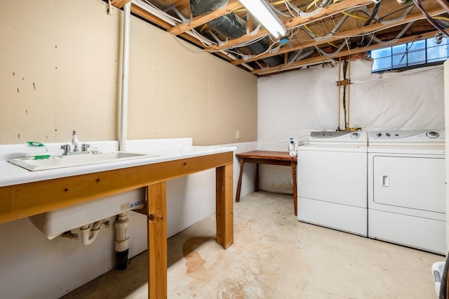 clothes washing area featuring a sink, laundry area, and washing machine and clothes dryer