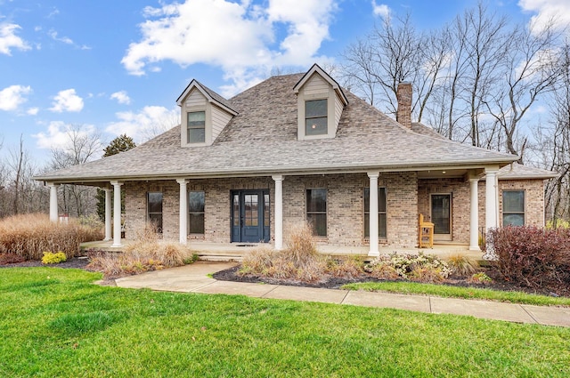 view of front of property with brick siding, covered porch, a shingled roof, and a front lawn