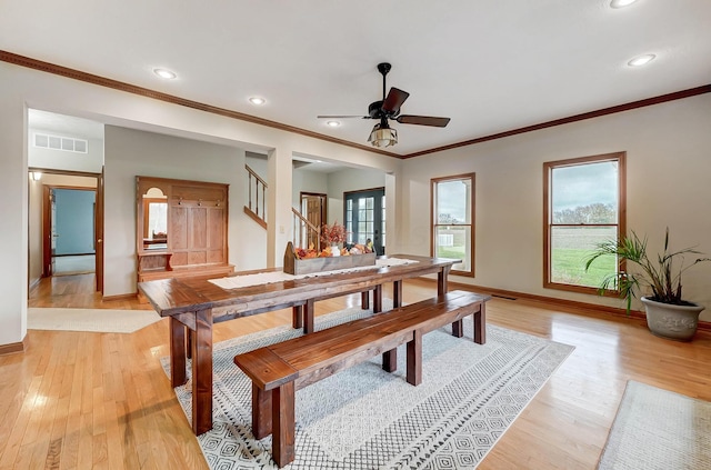 dining area featuring stairway, baseboards, visible vents, light wood-style flooring, and crown molding