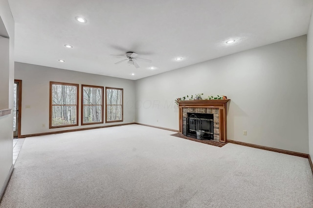 unfurnished living room featuring carpet flooring, recessed lighting, a tile fireplace, and baseboards