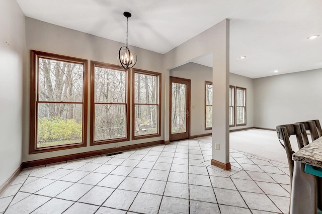 interior space with light tile patterned floors, visible vents, an inviting chandelier, and baseboards