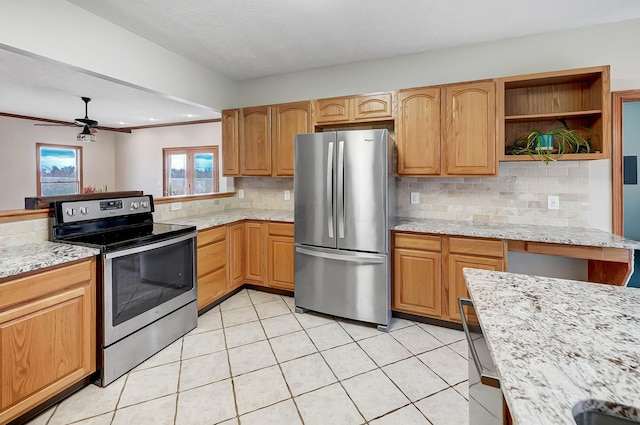 kitchen featuring light stone countertops, light tile patterned flooring, appliances with stainless steel finishes, crown molding, and tasteful backsplash