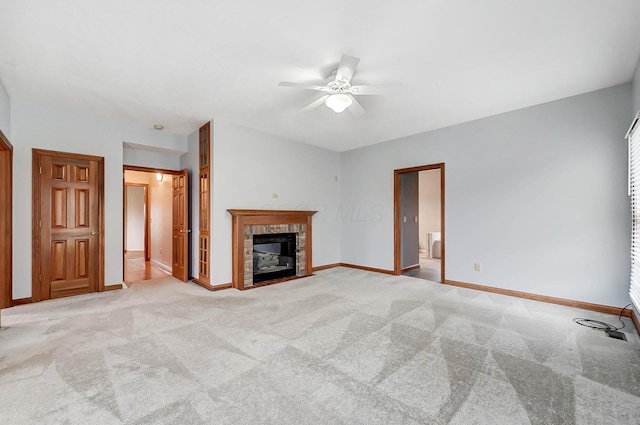 unfurnished living room with a tiled fireplace, light colored carpet, baseboards, and ceiling fan