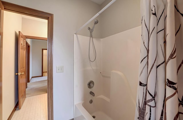 bathroom featuring baseboards and shower / bath combo