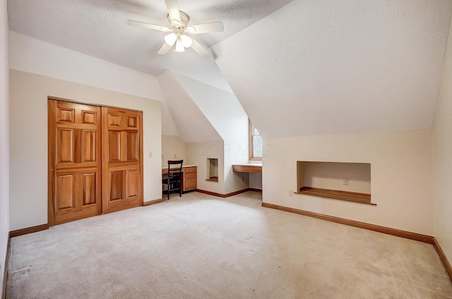 bonus room with a textured ceiling, lofted ceiling, and carpet floors