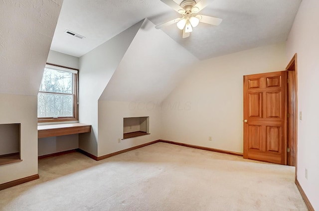 additional living space with carpet flooring, baseboards, visible vents, and vaulted ceiling