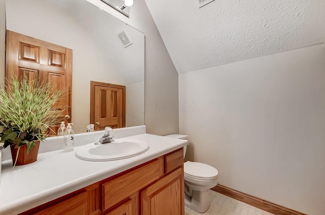 bathroom featuring visible vents, toilet, vanity, vaulted ceiling, and a textured ceiling