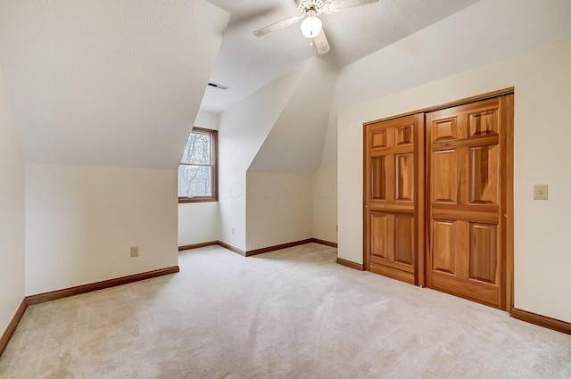 additional living space featuring visible vents, ceiling fan, baseboards, carpet, and lofted ceiling