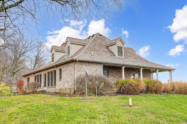 view of home's exterior featuring a yard, brick siding, and roof with shingles