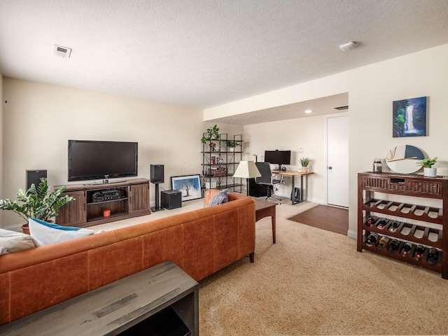 carpeted living room with visible vents, baseboards, and a textured ceiling