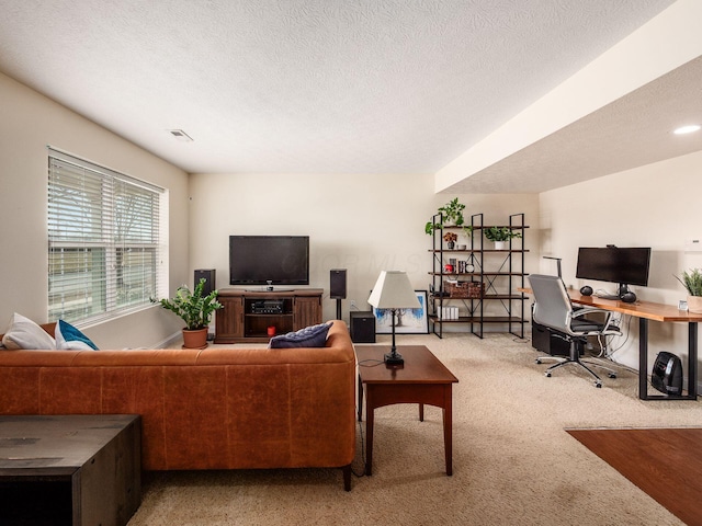 living room featuring light colored carpet, visible vents, and a textured ceiling