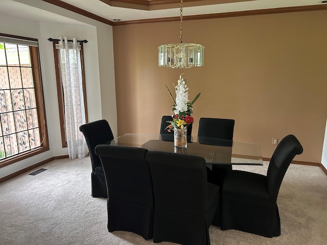 carpeted dining space with visible vents, crown molding, baseboards, a raised ceiling, and a notable chandelier