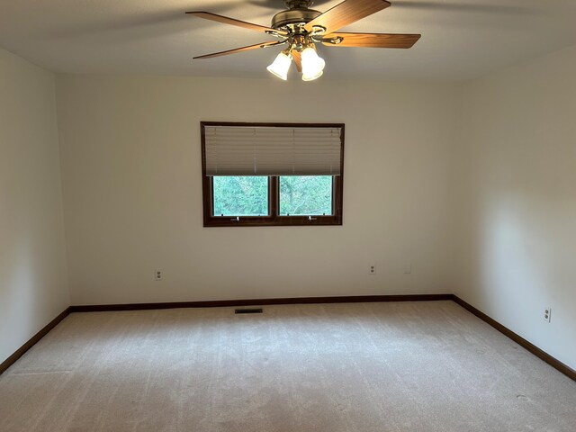 unfurnished room featuring a ceiling fan, baseboards, visible vents, and light carpet