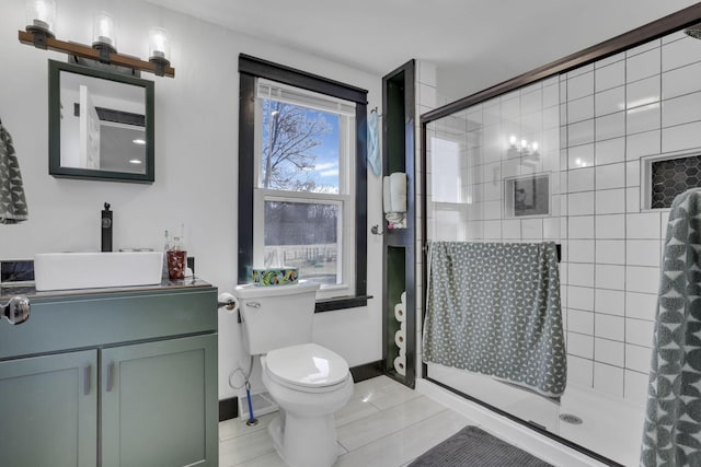 bathroom with a shower stall, baseboards, toilet, tile patterned floors, and vanity