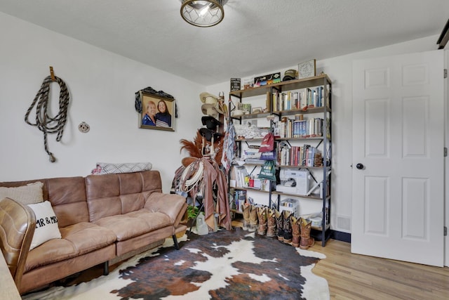 living area with a textured ceiling and wood finished floors