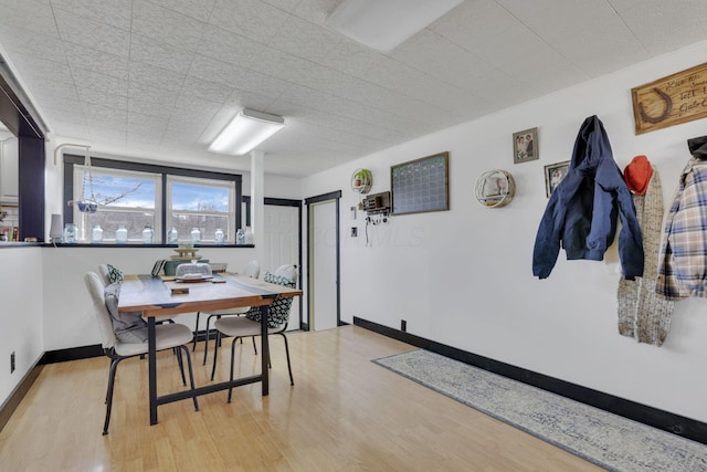 dining area with baseboards and light wood-style flooring