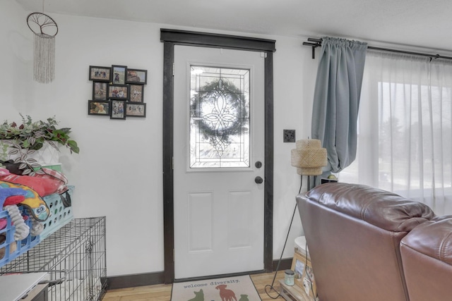 foyer with baseboards and light wood-style floors