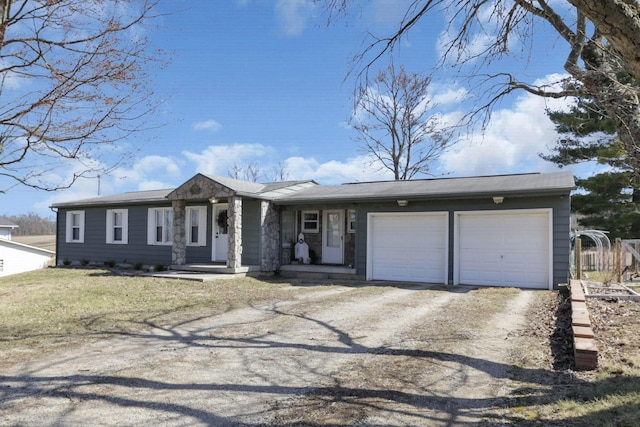 view of front of property with fence, a garage, and dirt driveway