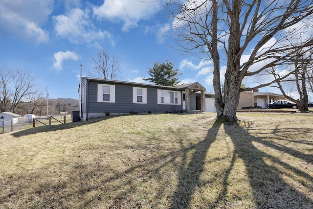 ranch-style home featuring a garage, a front yard, and fence