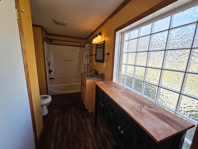 full bath featuring wood finished floors, visible vents, a textured ceiling, crown molding, and toilet