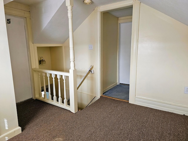 hallway featuring lofted ceiling and carpet flooring