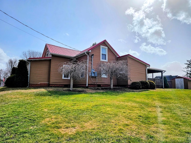 view of side of property with metal roof, an outbuilding, a lawn, and a shed