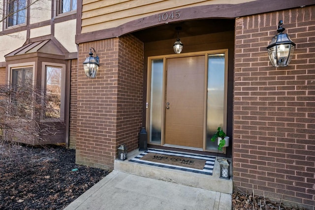 view of exterior entry featuring brick siding