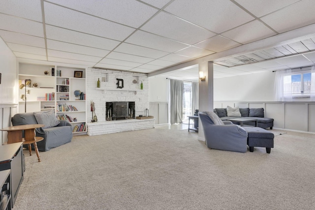 carpeted living area with a paneled ceiling and a brick fireplace