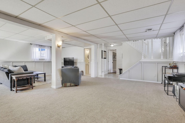 interior space with stairway, carpet, visible vents, a paneled ceiling, and a decorative wall