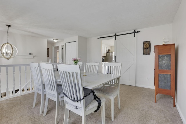 dining room with light carpet, a notable chandelier, baseboards, and a barn door