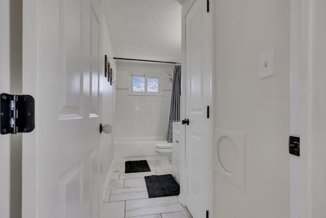 full bath with marble finish floor, a textured ceiling, toilet, and shower / bath combo