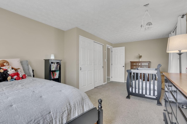 bedroom with light colored carpet and a textured ceiling