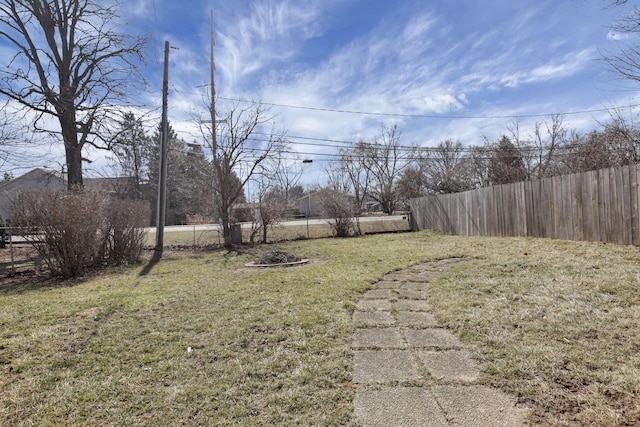 view of yard with an outdoor fire pit and fence