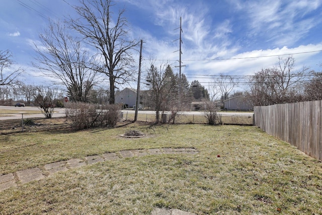 view of yard with fence and a fire pit