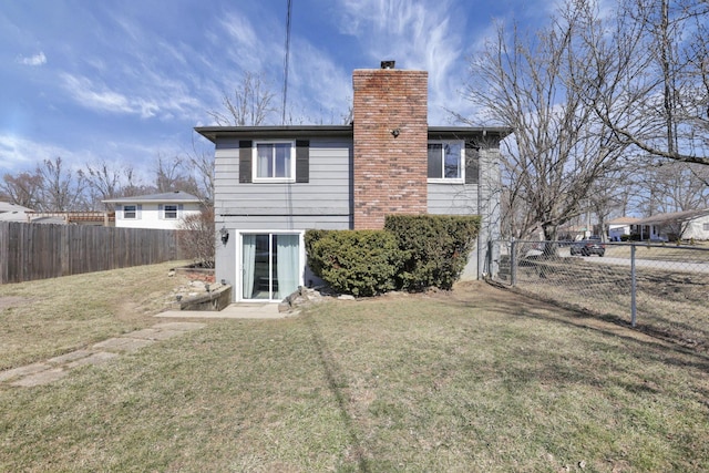 rear view of house featuring a yard, fence private yard, and a chimney